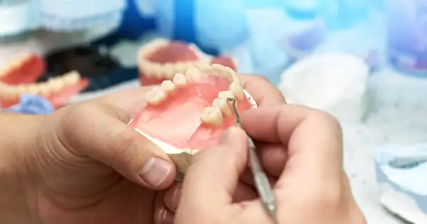 Protetyk stomatologiczny pracuje nad protezą zębową, która może być refundowana przez NFZ.