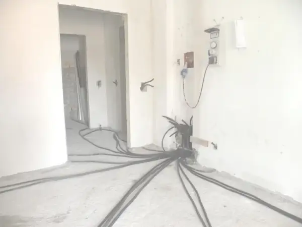 Rifacimento impianto elettrico in corso. Cavi neri si diramano dal muro, pronti per la manutenzione ordinaria o straordinaria.