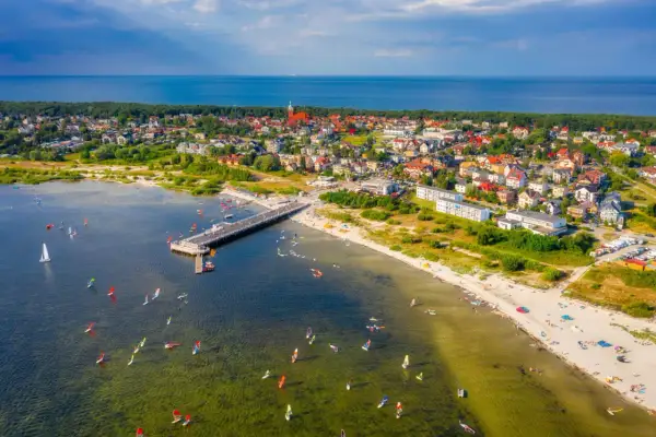 Jastarnia atrakcje: wiatr, deski i słońce na Zatoce Puckiej. Widok na molo, plażę i miasteczko.