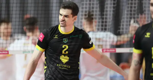 Szymański siatkarz w czarnej koszulce z numerem 2, zdeterminowany na boisku.