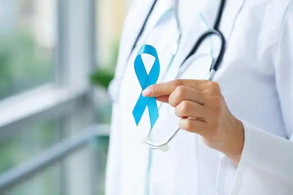 Lekarz trzyma niebieską wstążkę, symbol walki z rakiem prostaty. Badanie rezonansem magnetycznym prostaty jest kluczowe w diagnostyce.