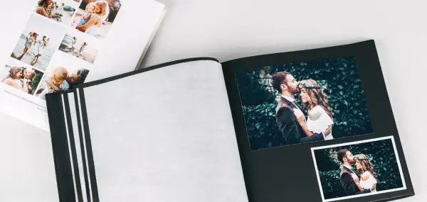 Otwarty album ze zdjęciami pary młodej i rodziny. Świetny pomysł na album, by zachować wspomnienia.