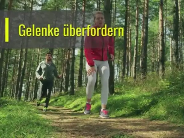 Zwei Läufer im Wald. Eine Frau hält sich das Knie, während ein Mann hinter ihr joggt. Die Frage ist, ob joggen gesund ist, wenn man die Gelenke überfordert.