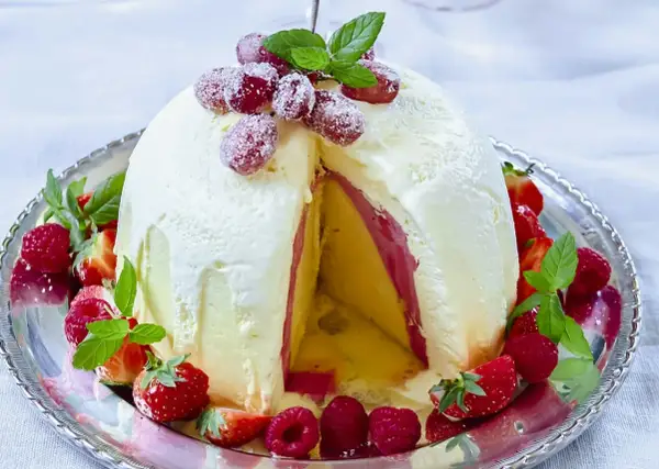 En magnifik elle nyårsdessert, en kupol av glass med lager av frukt och bär, dekorerad med färska jordgubbar och hallon.