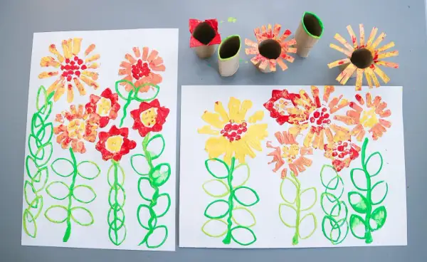Barnens pyssel blommor med färgglada stämplar av toarullar.