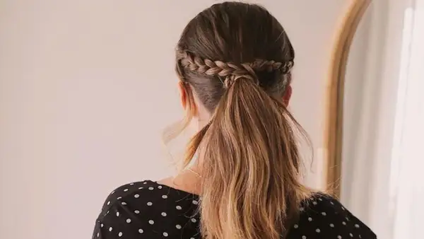 Peinados romería: coleta baja con trenza diadema, ideal para un día de campo o celebración.