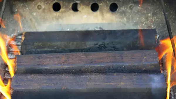 Holzofen richtig heizen: Briketts brennen mit Flammen.
