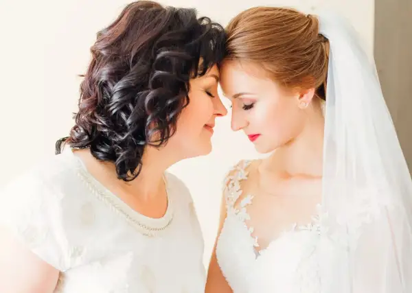 Mama i córka, obie elegancko na ślub córki, dzielą wzruszającą chwilę.