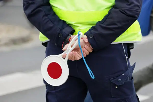 Policjant z tarczą stop. Uważaj na drogach, bo punkty karne 2025 mogą Cię zaskoczyć.