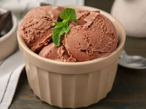 Schokoladeneis in einer Schale, garniert mit Minze. Perfekt für alle, die gerne Eis selber machen und den Sommer genießen.