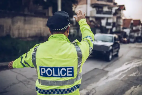 Policjant w odblaskowej kamizelce kieruje ruchem. Może to być kontrola drogowa, która przypomni o odsetkach za niezapłacony mandat w Niemczech.