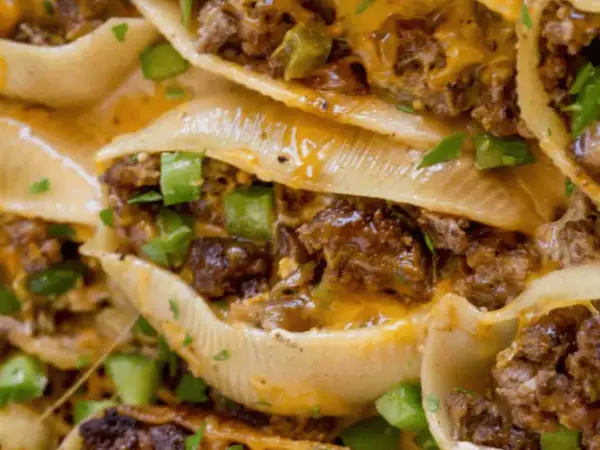 Close-up of cheesy, savory philly shell pasta stuffed with seasoned ground beef and green peppers, a delicious comfort food.