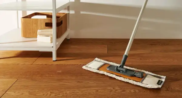 Mocio pronto per pulire pavimento marmo molto sporco. Sulla mensola, una cesta in legno e saponi.