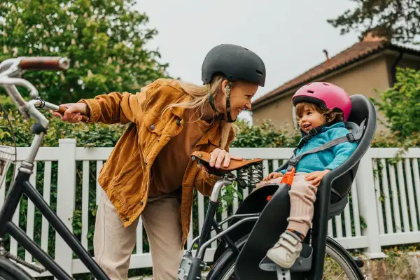 Kvinna med cykelvagn och barn i olika ålder, redo för en tur.