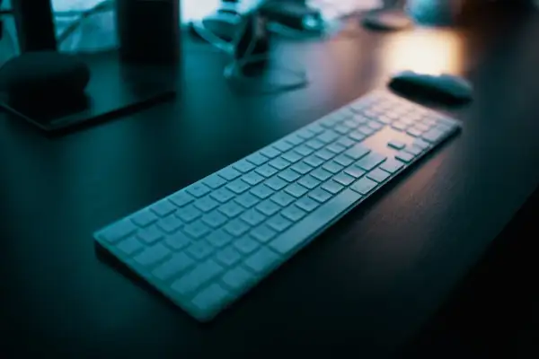 Klawiatura na biurku, gotowa do pracy. Dowiedz się, jak napisać ź na laptopie, by ułatwić sobie pisanie.