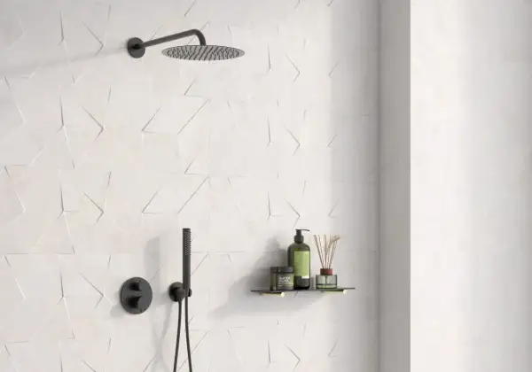 Ducha moderna con azulejo rectificado de diseño geométrico en blanco. Incluye rociador, grifería negra y estante con productos de baño.