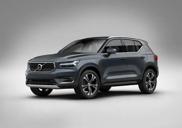 Elegancki, ciemnoszary Volvo XC40 prezentuje się na tle jasnej ściany, gotowy na miejskie wyzwania.