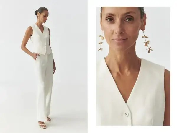 Elegancka kobieta w białej kamizelce i spodniach pokazuje, jak nosić kamizelkę na co dzień i od święta.