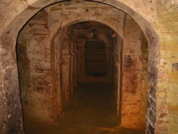 Corridoio sotterraneo con archi in mattoni e pietra a Monsampolo del Tronto, evocando misteri antichi.