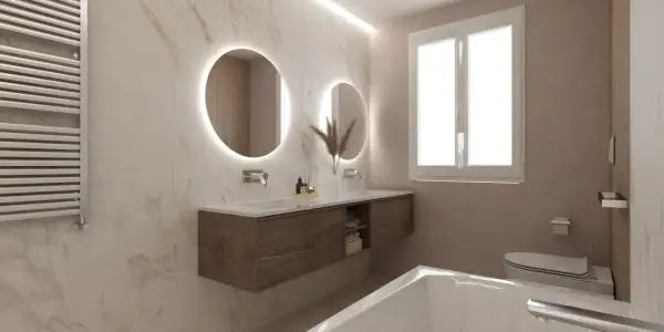Bagni eleganti con pareti in marmo, doppio lavabo con specchi rotondi illuminati, mobile sospeso in legno e vasca da bagno.