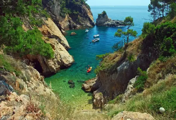 Kayak en cala turquesa, un paraíso que te hace preguntar: ¿cuáles son las mejores playas de España?