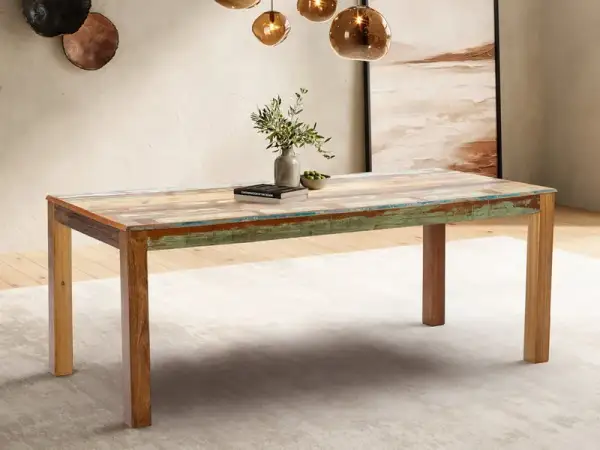 Ein rustikaler Esstisch aus verschiedenen Holzarten mit farbigen Akzenten, der in einem stilvollen Esszimmer steht.