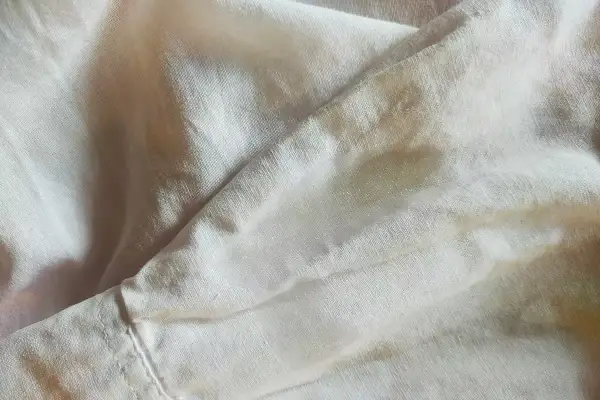 Tessuto chiaro con macchie, forse necessita di un detersivo per togliere la muffa dai tessuti.