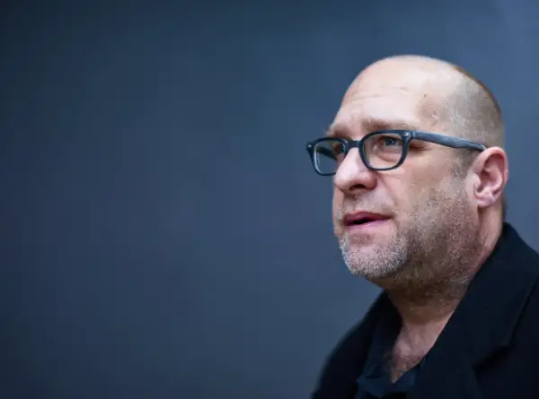 Portret mężczyzny w okularach, łysiejącego, z zarostem. Todd Hido w skupieniu.
