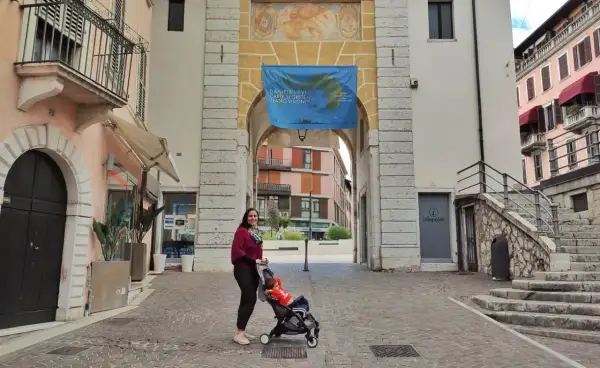 Donna con passeggino sotto un arco a Salò, tra le tante cose da fare.