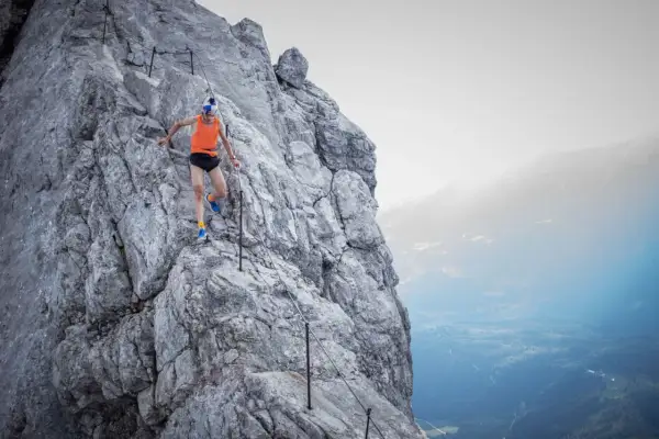 Anton Palzer bezwingt den Watzmann, ein Trailrunner in Aktion auf steilem Fels mit Sicherungsseil.