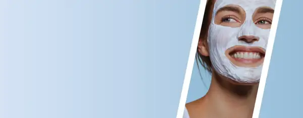 Mujer sonriente con mascarilla de arcilla blanca, disfrutando de un momento de cuidado facial.