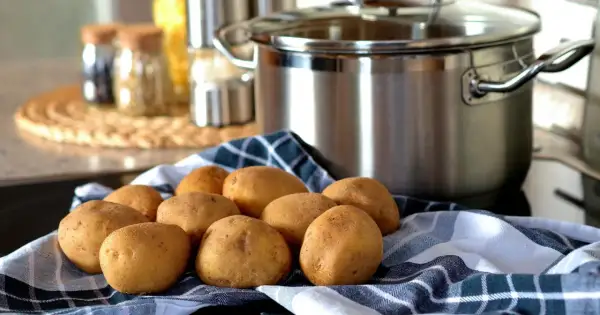 Ziemniaki na ręczniku, garnek w tle. Czas zacząć gotowanie, ale kiedy solić ziemniaki?