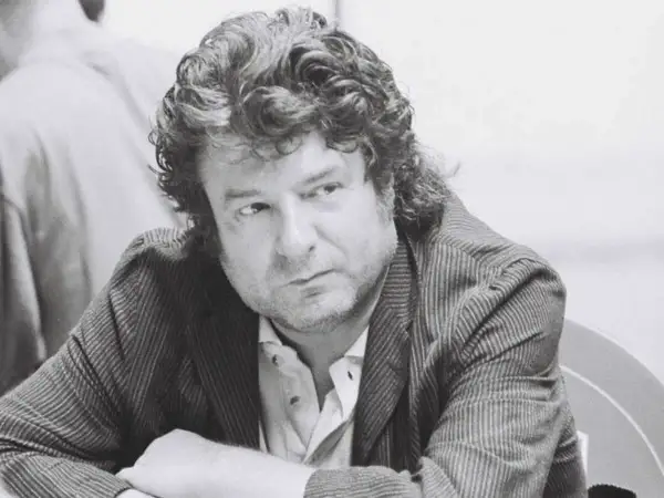 Enrique Morente joven, con su melena rizada y mirada pensativa, viste chaqueta de rayas.