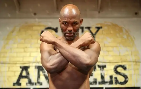 Bernard Hopkins, the legendary boxer, stands with arms crossed, a determined look on his face. He's a true inspiration, a master of his craft, and a great trainer.