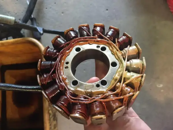 El estator de una moto, con sus bobinas de cobre recubiertas de barniz, listo para generar energía.