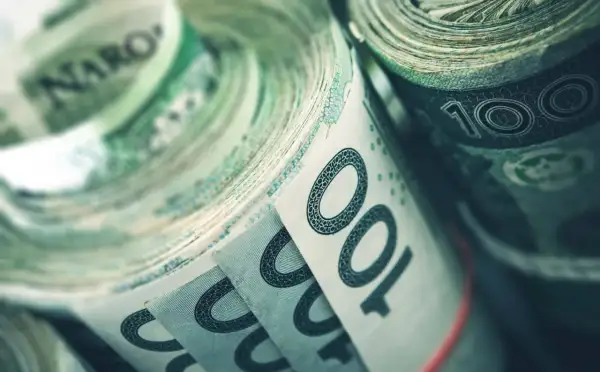 Zwijane banknoty 100 zł, symbolizujące fundusz rezerwy demograficznej, gotowe na przyszłe wyzwania.