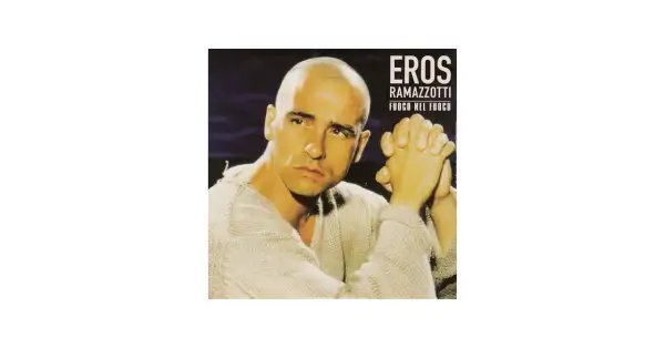 Eros Ramazzotti w swetrze, z dłońmi złożonymi w geście modlitwy. Okładka albumu "Fuoco nel fuoco".