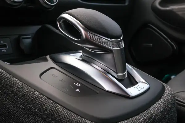 Levier de vitesse d'une b boite auto moderne, avec indicateurs lumineux R, N, D, B. Le design est futuriste et élégant.