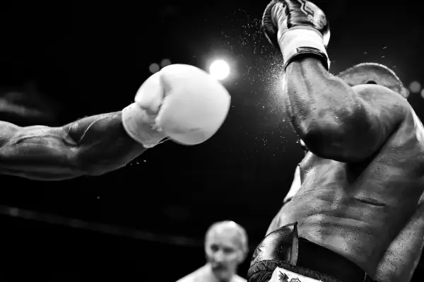 Un pugno in arrivo, un momento catturato da fotografi sportivi famosi. La polvere vola, l'intensità è palpabile.