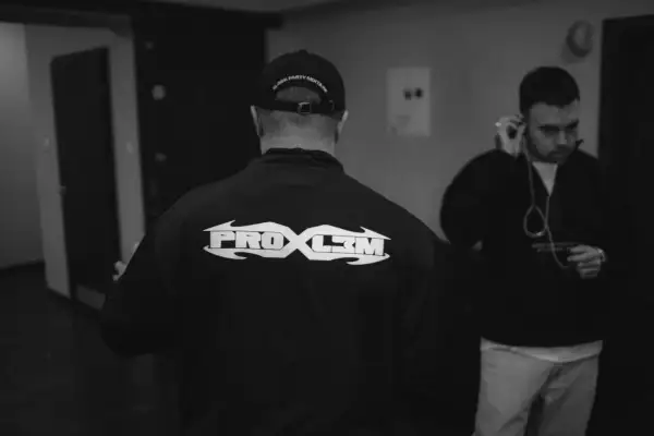 Dwóch mężczyzn, jeden w czapce z napisem "block party mixtape", drugi słucha muzyki. Na bluzie pierwszego widnieje napis "PROBL3M".