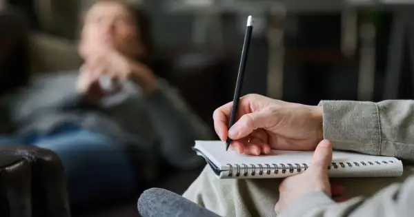 Psycholog słucha i notuje, pomagając pacjentowi zrozumieć siebie.