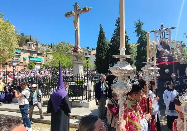 Procesiones Semana Santa Viernes Santo en Granada. Nazarenos con túnicas moradas y pasos procesionales iluminados por velas.