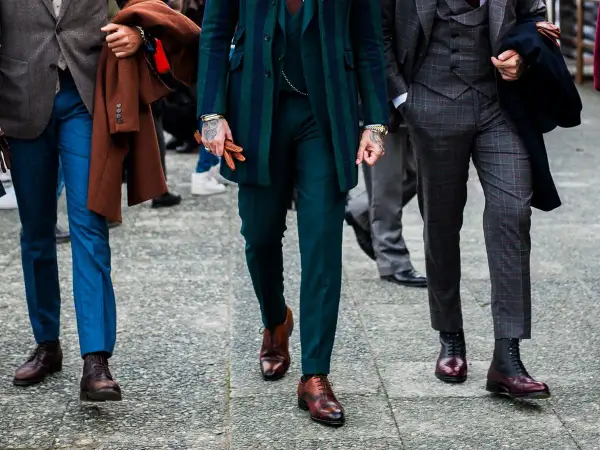 Uomini con abiti eleganti, focus su lunghezza pantalone con mocassino e stivali.