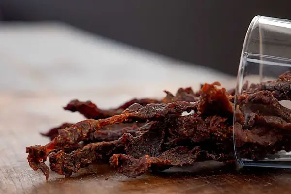 Leckeres beef jerky selber machen ist gar nicht schwer! Hier ist ein Haufen selbstgemachtes Beef Jerky, das aus einem Glas gekippt wurde.