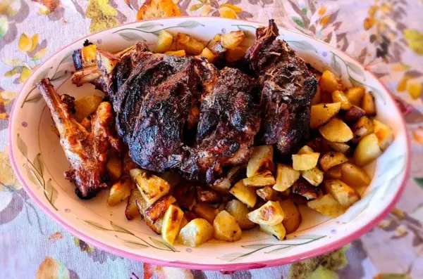 Un succulento agnello al forno con patate dorate, un piatto che profuma di tradizione e festa.