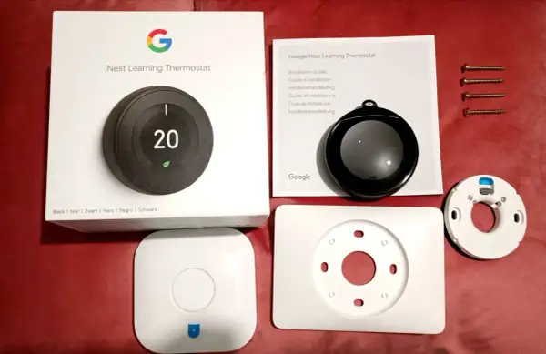 Kit pour l'installation d'un thermostat Nest Learning. Boîte, manuel, thermostat, socle et vis.