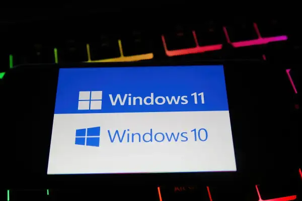 Ekran porównuje Windows 10 i Windows 11, pomagając wybrać najlepszy system Windows 10 czy 11 do gier. Klawiatura RGB w tle dodaje klimatu.