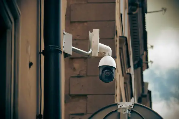 Kamera monitoringu na ścianie budynku, gotowa do zarejestrowania każdego zdarzenia, stanowiąc dowód kradzieży.