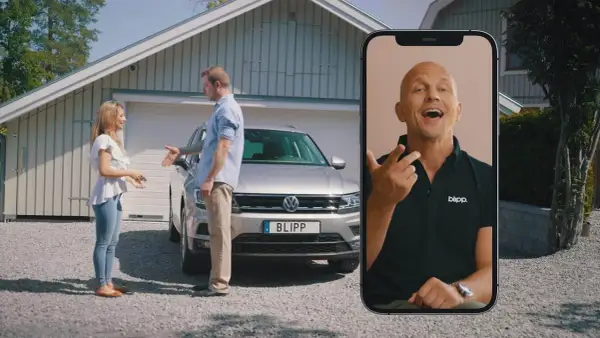 Kvinna och man diskuterar en bil med fel. En man på en mobilskärm ger råd om hur man kan byta in bil med fel.