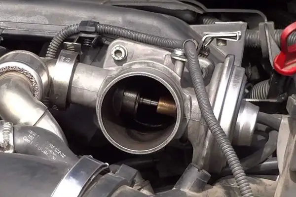 Cuerpo de acelerador de Peugeot, posible causa de DTC 0404. Se observa el mecanismo interno y la válvula.